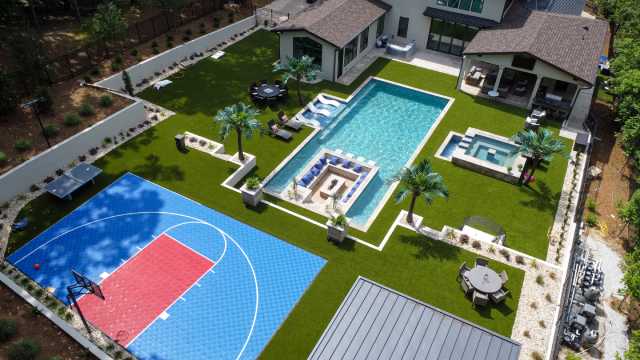 Outdoor artificial grass backyard with basketball court