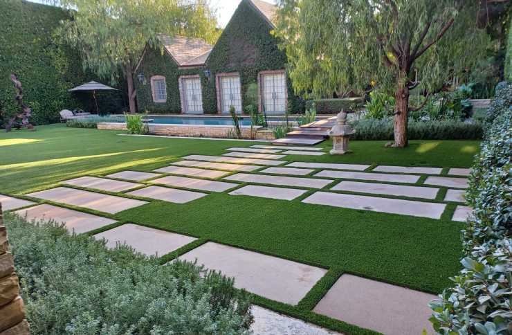 Artificial grass backyard with walkway and pool installed by SYNLawn